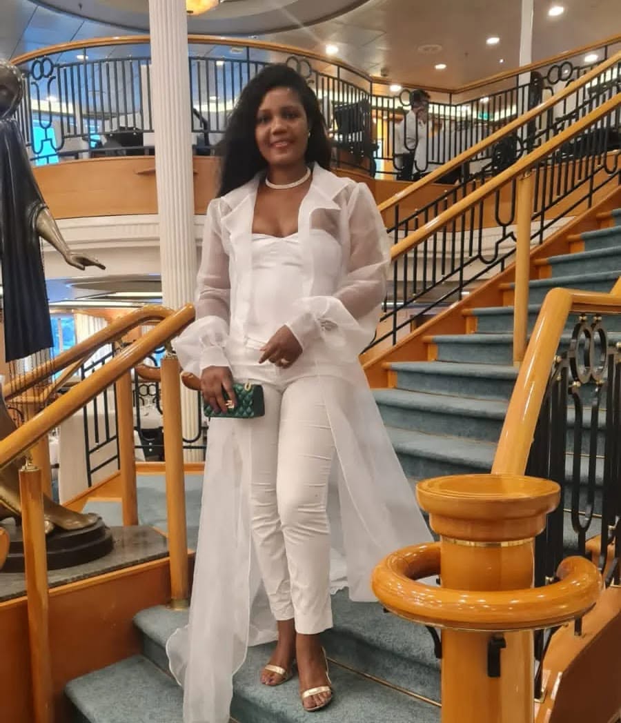 Kadine Reynolds in white, on a cruise ship staircase