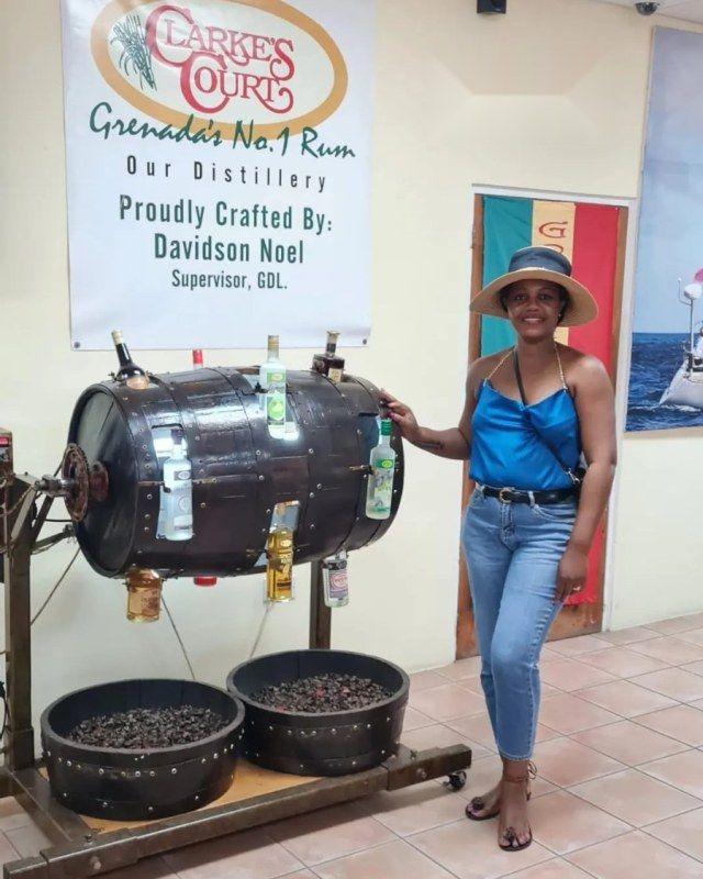 Kadine Reynolds beside the rum display at the Clarke&rsquo;s Court distillery, Grenada