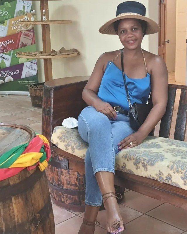 Kadine Reynolds seated on a barrel bench at a rum distillery, Grenada